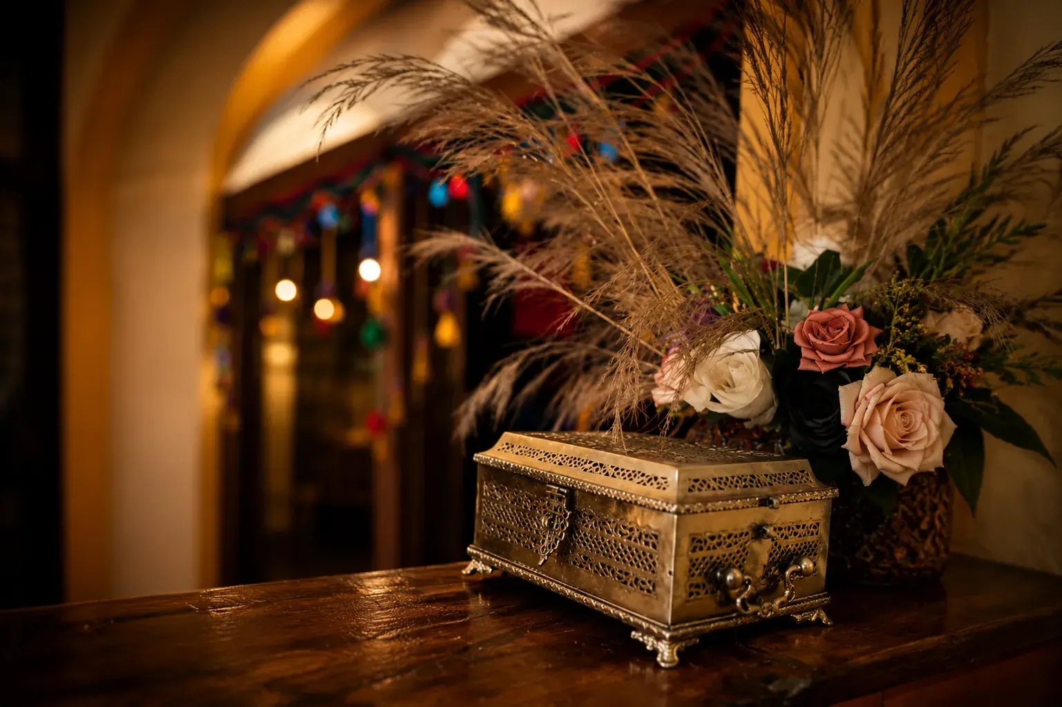 An inlaid chest with roses and dried feathers on the table