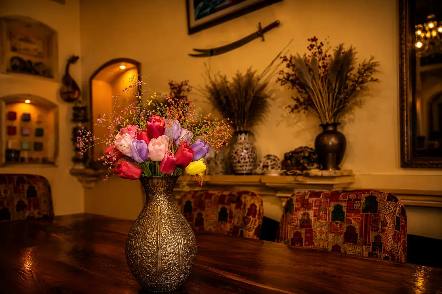 Flowers in an engraved vase against the decorated wall