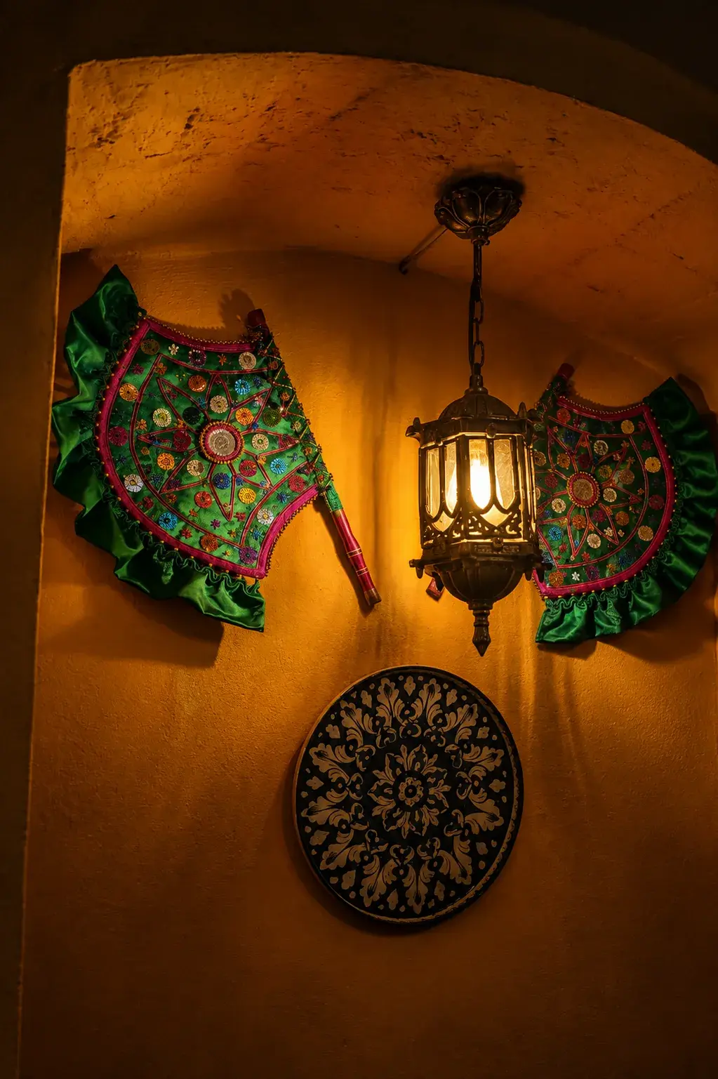 A hanging lantern and painted plates on the ochre wall