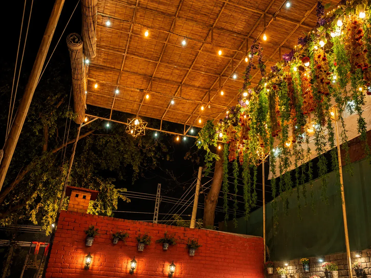 The covered walkway strung with lights and hanging greenery