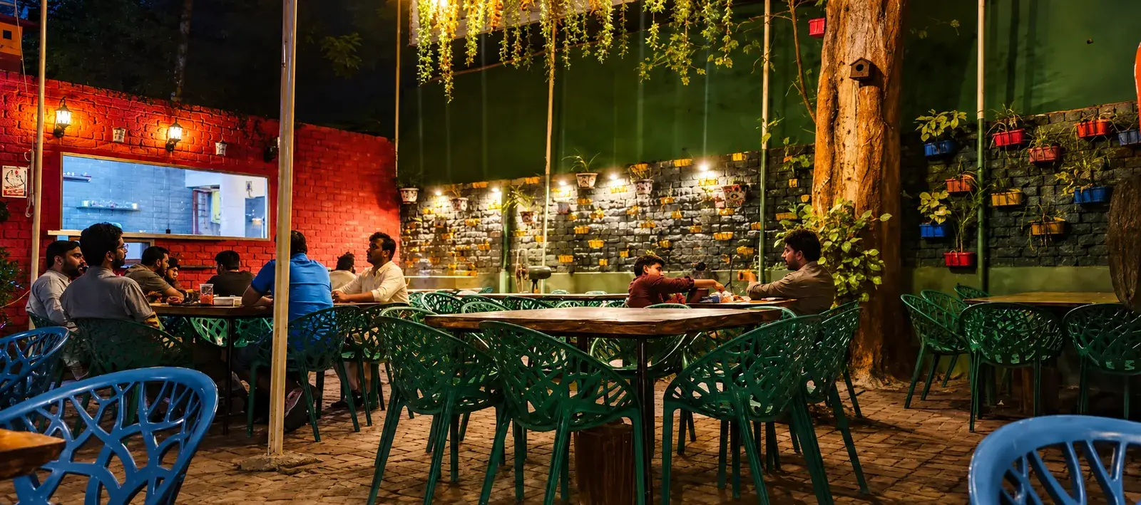 A long table laid with roses in the garden seating at Shahi Rasoi